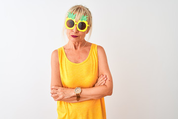 Middle age woman on vacation wearing pineapple sunglasses over isolated white background skeptic and nervous, disapproving expression on face with crossed arms. Negative person.