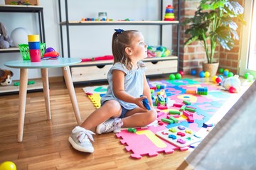 Young beautiful blonde girl kid enjoying play school with toys at kindergarten, smiling happy playing at home