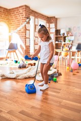 Young beautiful blonde girl kid enjoying play school with toys at kindergarten, smiling happy playing at home