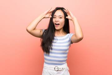 Teenager asian girl over isolated pink background with surprise expression