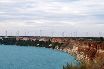  a lot of  wind generators on a high seashore
