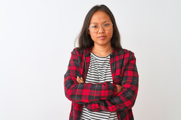 Fototapeta premium Young chinese woman wearing t-shirt jacket and glasses over isolated white background skeptic and nervous, disapproving expression on face with crossed arms. Negative person.