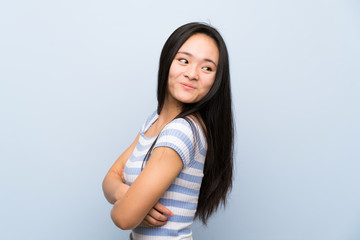 Teenager asian girl over isolated blue background laughing