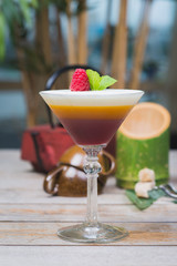 Tiramisu traditional dessert in a glass goblet on a wooden table.