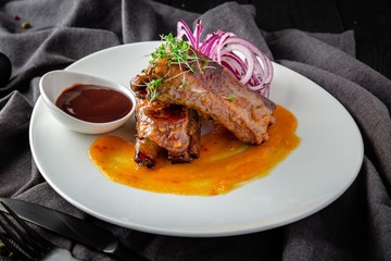 Baked Pork Ribs with BBQ Sauce. Restaurant menu. Background black boards.