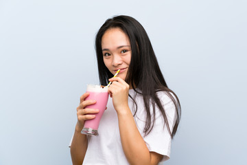 Naklejka premium Teenager asian girl holding a strawberry milkshake