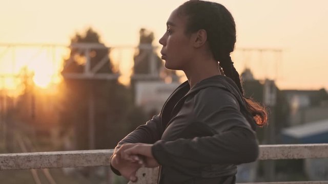 Back View Of African American Concentrated Woman In Sportswear  Doing  Warm Up Exercises While Working Out On Old Bridge