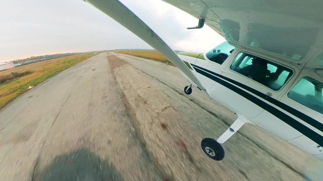 Light plane landing on a runway in fields.