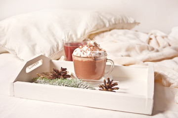 Cup of cocoa on the white tray on the bed early winter morning