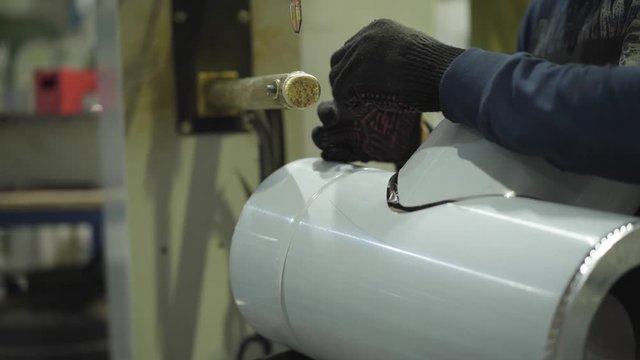Close-up of male hands preparing metal product for the processing with the use of hydraulic riveting machine. Steel industry, steel production, manufacturing, industrial, equipment.