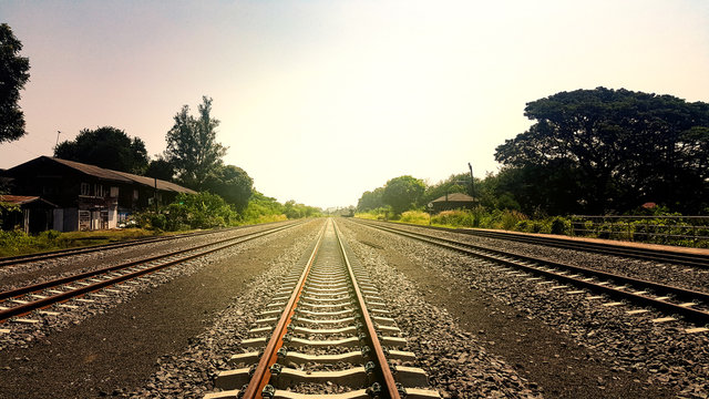 The countryside railway tracks in Thailand stretch along the path to the next destination