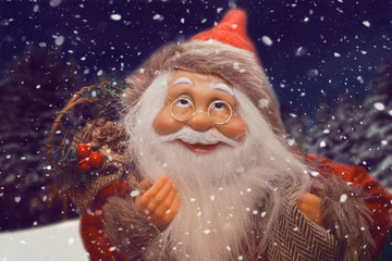 Miniature Christmas funny toy Santa. Winter landscape on the background.