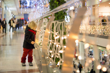 Fashion toddler boy in the city center shopping mall on Christmas