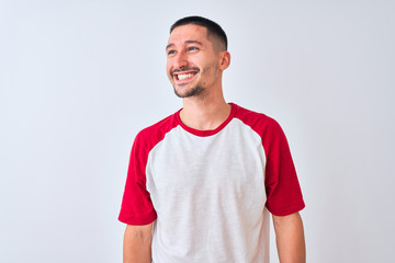 Young handsome man standing over isolated background looking away to side with smile on face, natural expression. Laughing confident.