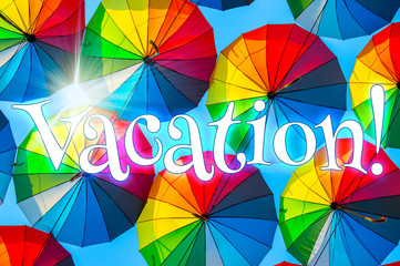 Vacation! Joyful text on the background of colorful umbrellas in the sky.