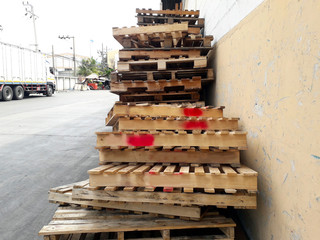 A lot of brown pallets are laid on the cement floor.