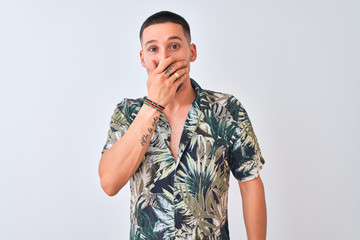 Fototapeta premium Young handsome man wearing Hawaiian summer shirt over isolated background shocked covering mouth with hands for mistake. Secret concept.