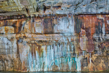 Landscape of mineral stained cliff along the eroded sandstone shoreline of Lake Superior, Pictured Rocks National Lakeshore, Michigan’s Upper Peninsula