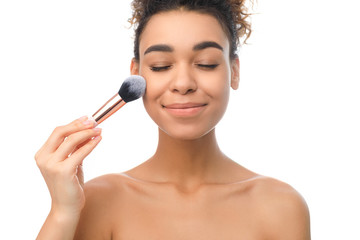 Afro woman using brush tool, applying blush