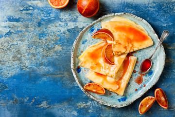 Homemade crepes pancakes served in ceramic plate with  orange sauce. French Crepe Suzette with...