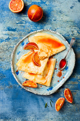 Homemade crepes pancakes served in ceramic plate with  orange sauce. French Crepe Suzette with...