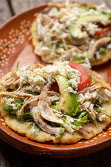 Yucatecan salbutes with chicken meat on wooden background