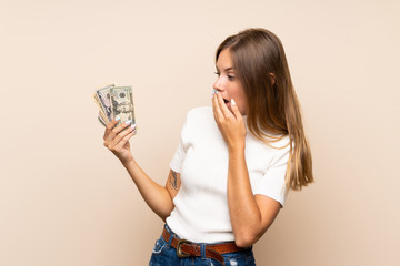 Young blonde woman over isolated background taking a lot of money