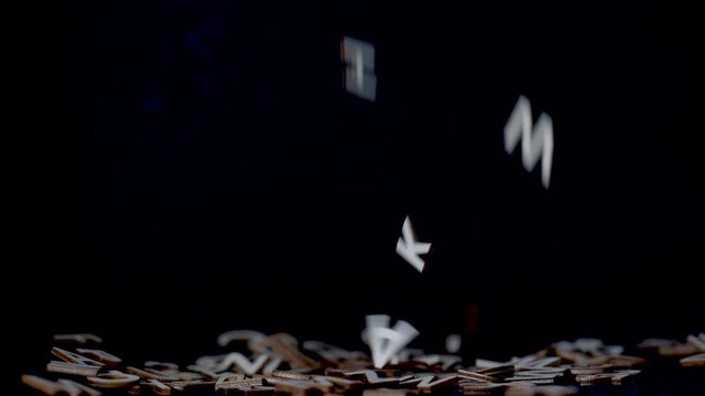 Conceptual shot of alphabet letters falling on a black background in slow motion with copy space. Representing memory loss, brainstorming, writing, amnesia, confusion or aphasia.