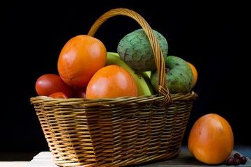wicker basket with autumn fruits and lemons