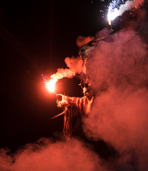 Krampus with fire and red smoke at traditional public show Krampuslauf in Kaprun, Salzburg, Austria.