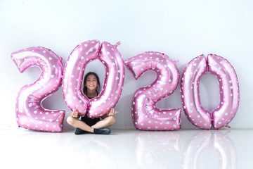 Asian little girls in sportswear are happy to play with numbers balloons 2020, balloons making the 2020 number