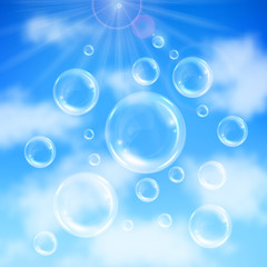 Realistic transparent floating soap bubbles on blue sky background. Design element for advertising booklet, flyer or poster