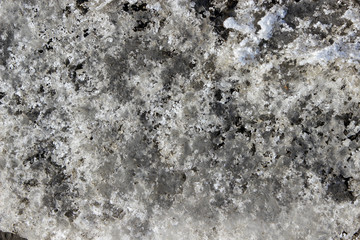 Texture of a dirty heavy jagged melting snow turning into ice 