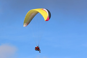 Tandem Paraglider flying wing in a blue sky	