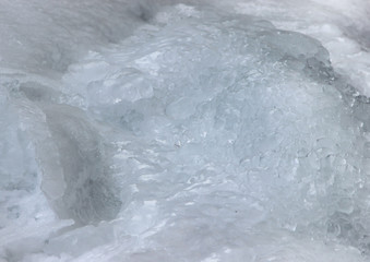 Closeup of a thick layer of ice and an accumulation of ice pellets on top of it