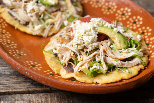 Yucatecan salbutes with chicken meat on wooden background