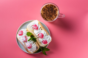 Obraz na płótnie Canvas Air cake with raspberries on a saucer. Kefir with cinnamon, fermented drink. Pink background