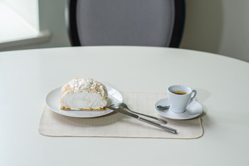 A delicious roll of bezrukov and a cup of coffee on a table in a cozy coffee shop