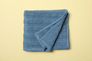 Blue towel on beige background, top view and close up