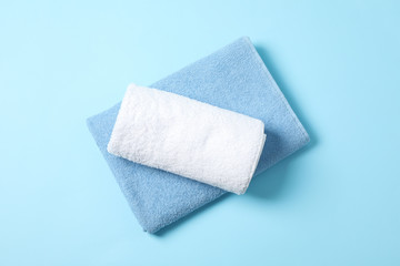 Folded towels on blue background, top view and space for text