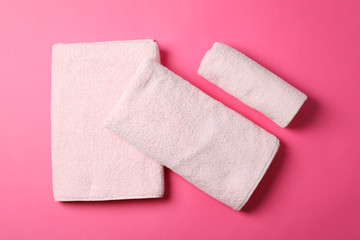 Composition with folded towels on pink background, top view