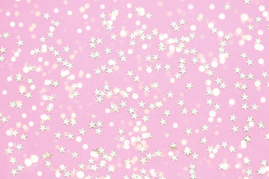Holiday background. Star glitter on pink background. Top view.