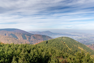 Fototapeta premium Hills and mountains on the horizon of beautiful nature with city in the forest valley view into vast distance of the Beskids Area during a windy sunny day captured in Radhost Pustevny area