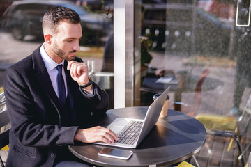 Attentive brunette male person staring at computer