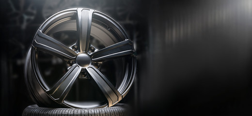 beautiful black alloy wheels made of aluminum on a dark background. exclusive wheels for expensive...