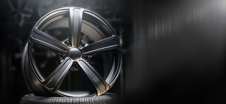 Fototapeta beautiful black alloy wheels made of aluminum on a dark background. exclusive wheels for expensive cars. Close up, copyspace