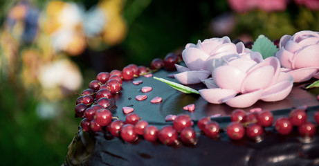 chocolate cake decorated with biscuit flowers, berries and hearts