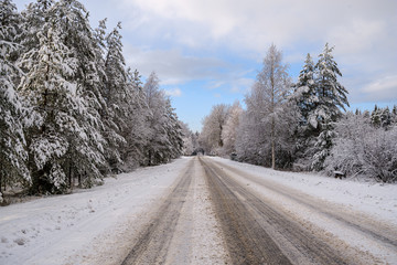 Obraz na płótnie Canvas car tracks in the snow on the winter road in sunny day