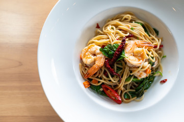 Spaghetti with spicy prawn on wooden table