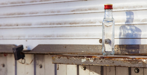 empty bottle of vodka alcoholism problem concept photography on kiosk windowsill dirty poor urban environment wallpaper pattern empty copy space 